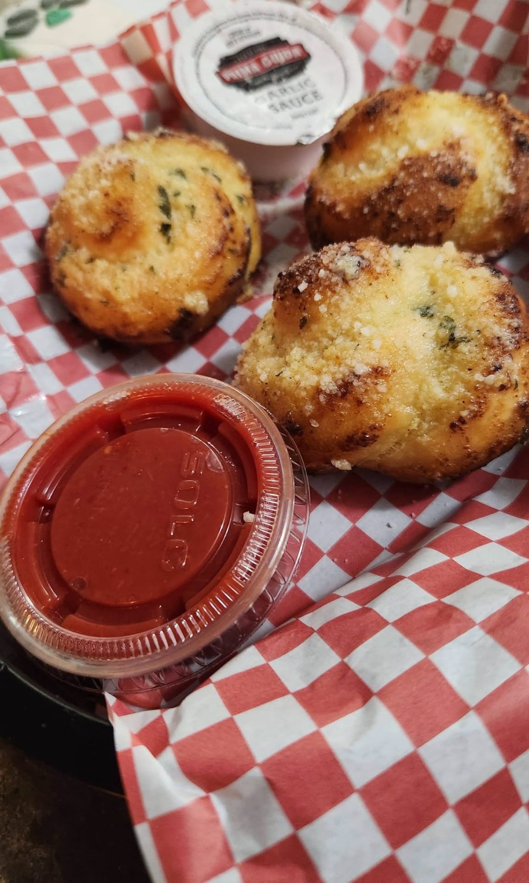 Garlic knots dusted with cheese and herbs, served with marinara